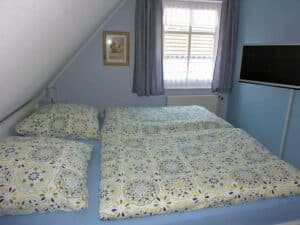 Elternschlafzimmer mit Doppelbett und TV